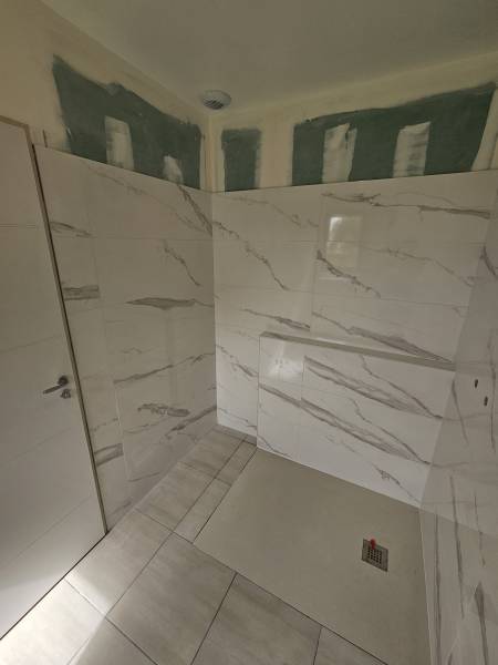 Société de carrelage proche Varengeville sur Mer : étanchéité de la douche et pose de la faïence 60x120 au mur de cette salle de bains