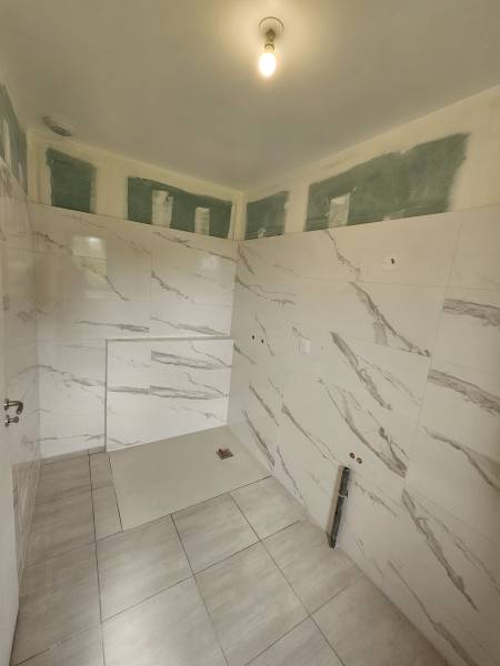 Société de carrelage proche Varengeville sur Mer : étanchéité de la douche et pose de la faïence 60x120 au mur de cette salle de bains