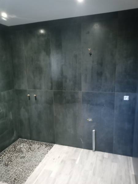 Application de carrelage mural grand format effet béton dans une salle de bain proche Le Havre 76