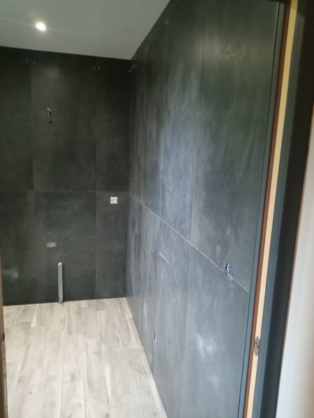 Application de carrelage mural grand format effet béton dans une salle de bain proche Le Havre 76